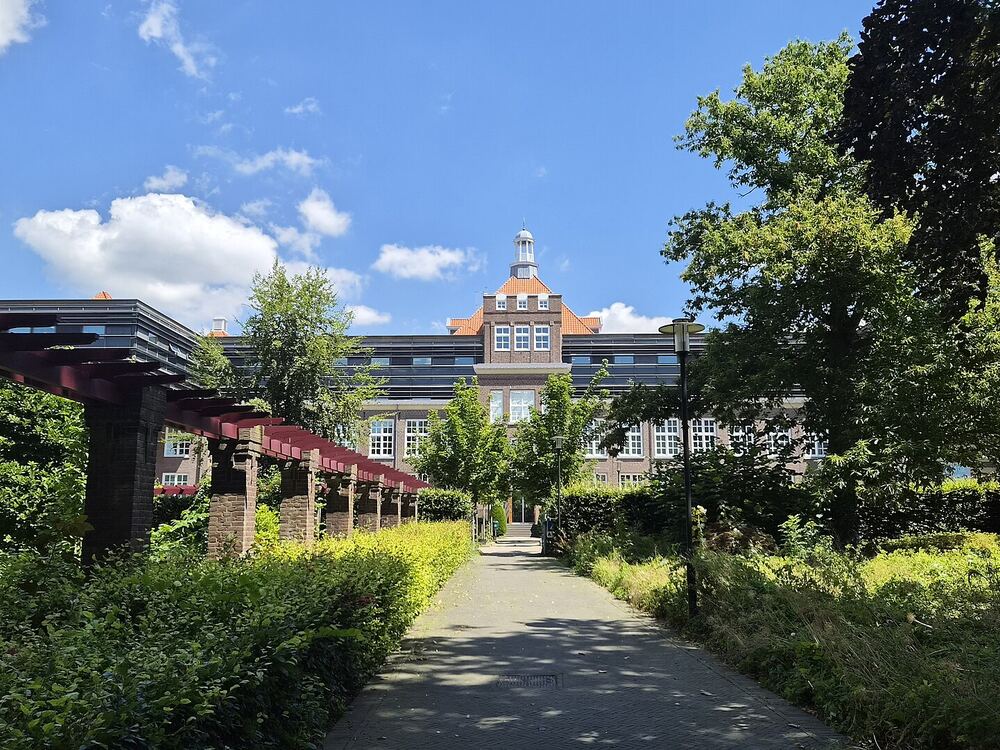 Een pad onder een pergola door de rozentuin van het ABP-park in Heerlen